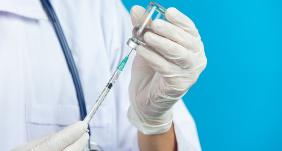image médecin tenant une aiguille et flacon du vaccin covid